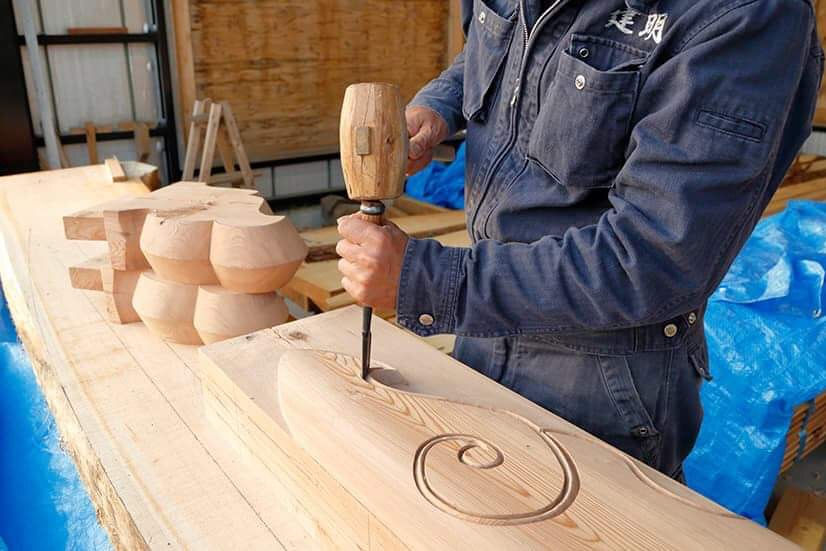 職人が木材に彫り込みを入れている作業風景